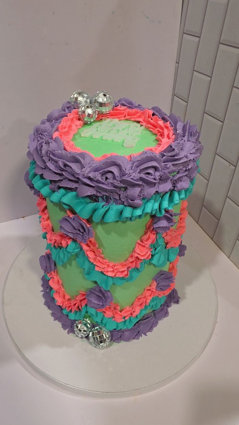Retro piped buttercream cake in purple, teal and coral with disco ball accents