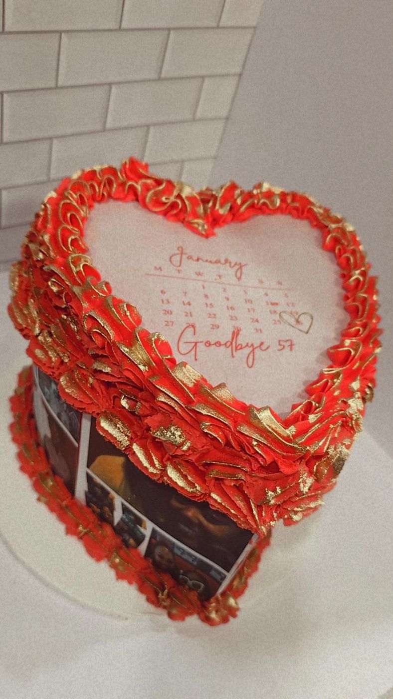Red heart-shaped cake with ruffled piping and a calendar design