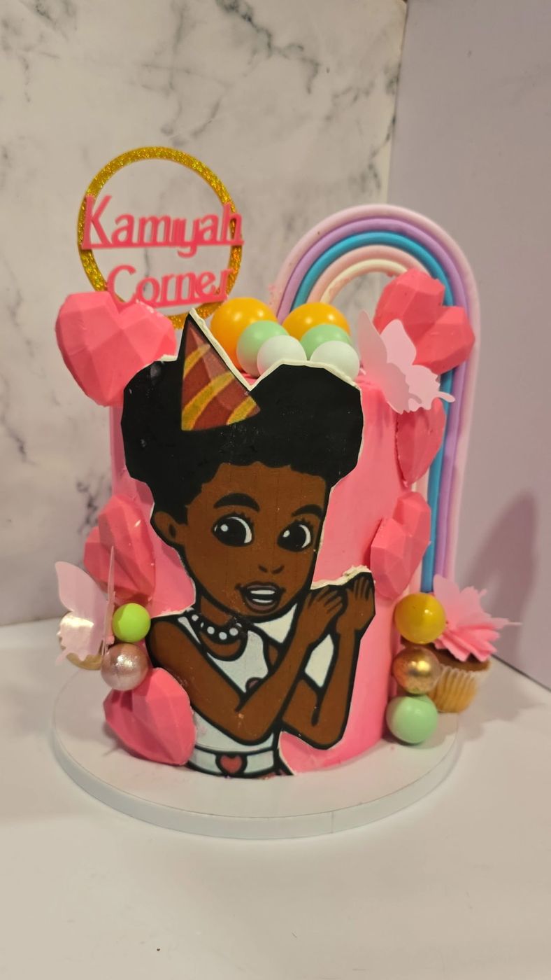 Pink birthday cake with a custom cartoon illustration and a rainbow