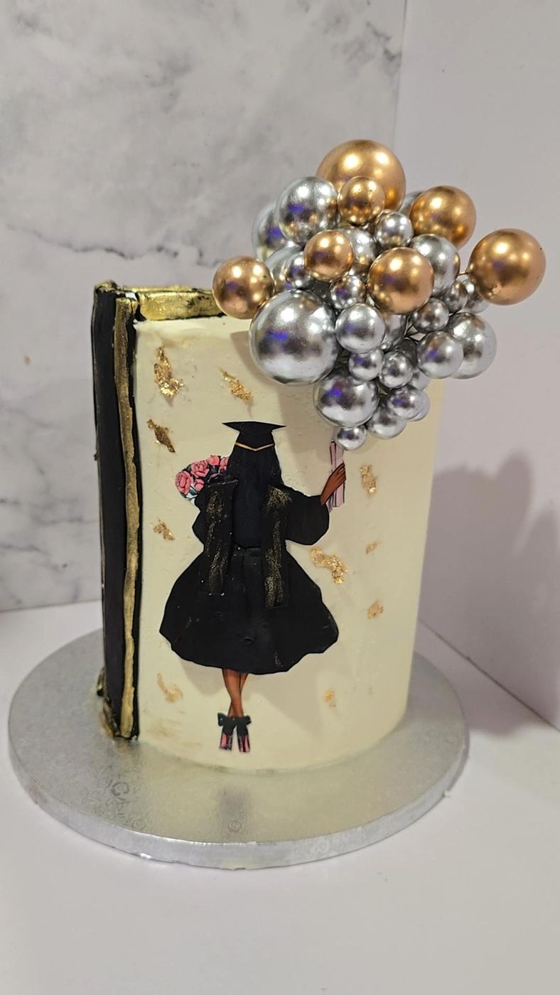 Graduation cake with a graduate silhouette and silver and gold balloons